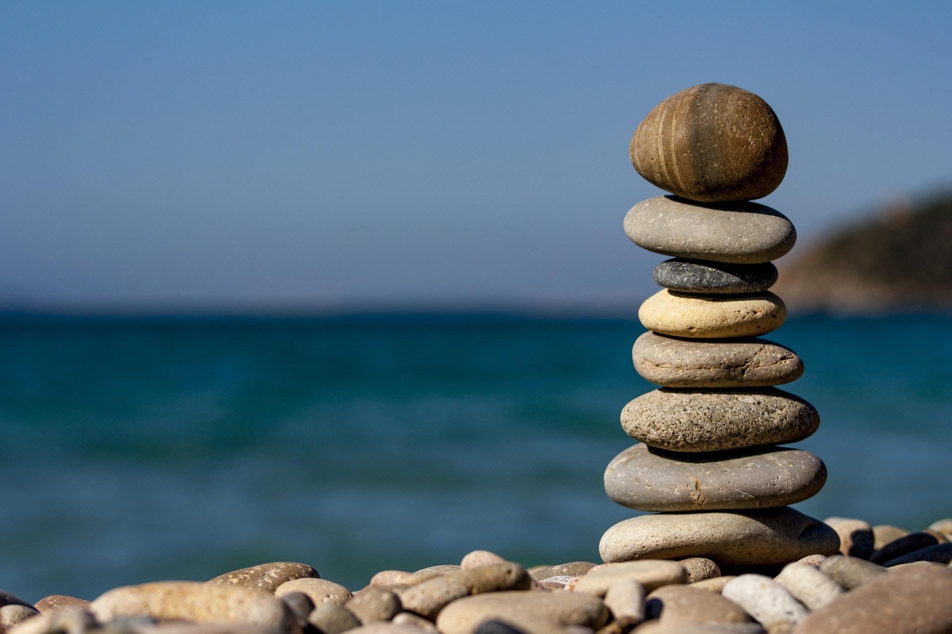 Stablede sten i balance ved havet – ro og balance gennem terapi